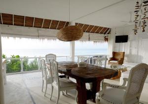 uma sala de jantar com mesa e cadeiras e o oceano em Sal Secret Spot em Uluwatu