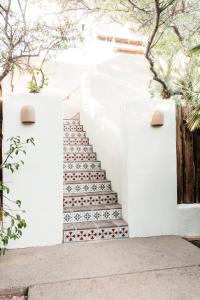 una escalera con baldosas rojas y blancas en una pared blanca en The JTH Tucson en Tucson