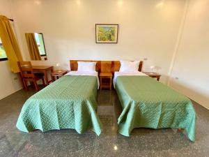 ein Hotelzimmer mit 2 Betten und einem Tisch in der Unterkunft Strutz Art Garden Resort in Bangued