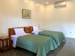 two beds in a hotel room with at Strutz Art Garden Resort in Bangued