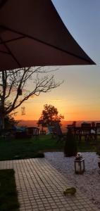 a sunset with an umbrella and tables and benches at ***** Quinta Do Pôr do Sol ***** in Figueira da Foz