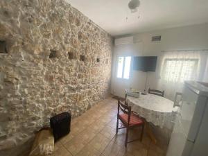 a kitchen with a stone wall with a table and chairs at Holiday house with WiFi Novi Vinodolski - 12241 in Novi Vinodolski +11 photos