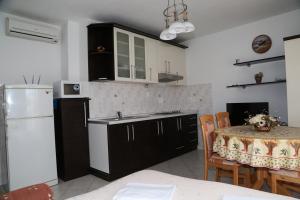 a kitchen with a table and a white refrigerator at Apartments by the sea Milna, Hvar - 12244 in Milna