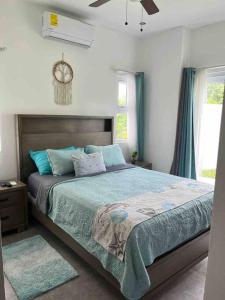 1 dormitorio con 1 cama grande con almohadas azules en Lapa Lodge G1, en Jacó
