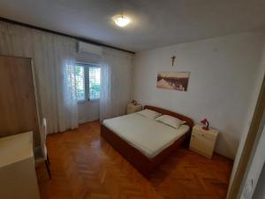 a bedroom with a bed and a cross on the wall at Apartments with a parking space Makarska - 12211 in Makarska