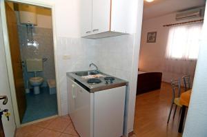 a small kitchen with a sink and a toilet at Apartments with a parking space Makarska - 12211 in Makarska