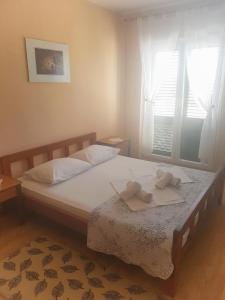1 dormitorio con 1 cama con 2 toallas en Apartments and rooms with parking space Solaris, Sibenik - 12269 en Šibenik
