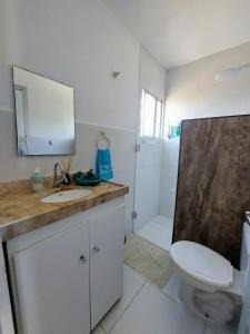 Baño blanco con lavabo y aseo en Zapipou - Apartamento aconchegante para você aproveitar o melhor de Pipa, en Pipa