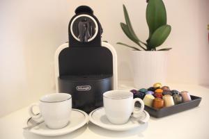 una macchinetta del caffè con due tazze sul tavolo di Guesthouse Interno 7 Luxury Rooms a Roma