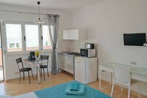 a small kitchen with a table and chairs in a room at Apartments by the sea Razanj, Rogoznica - 12280 in Rogoznica