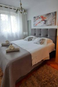 a bedroom with a large bed with two towels on it at Apartments by the sea Postira, Brac - 12291 in Postira