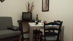 a dining room with a table with chairs and a bottle of wine at Apartments by the sea Ilovik, Losinj - 12275 in Ilovik