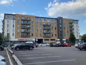 a parking lot with cars parked in front of a building at Luxury Modern 2 bed room apartment. in Belvedere