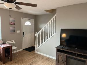 uma sala de estar com uma televisão de ecrã plano e uma escada em Carter #4 Two bedroom unit near Xavier Downtown em Cincinnati