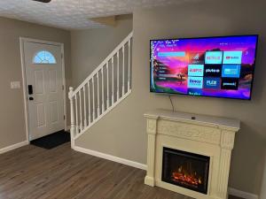 sala de estar con chimenea y TV de pantalla plana en Carter #6 Two Bedroom Apartment near Xavier, en Cincinnati