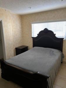 Un dormitorio con una cama y una ventana en Lovely Berryman Ave Apartment, en Los Ángeles