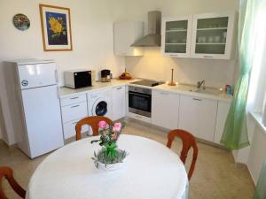 Una cocina con una mesa con un jarrón de flores encima. en Apartments by the sea Rabac, Labin - 12308, en Rabac