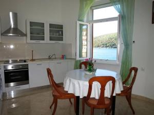 uma cozinha com mesa e cadeiras e uma janela em Apartments by the sea Rabac, Labin - 12308 em Rabac