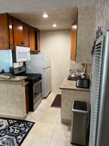 Una cocina con un refrigerador blanco y una estufa. en Lovely Berryman Ave Apartment, en Los Ángeles 7 fotos más