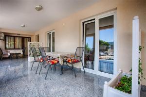 a dining room with a table and chairs and a balcony at Apartments with a parking space Komiza, Vis - 12325 in Komiža
