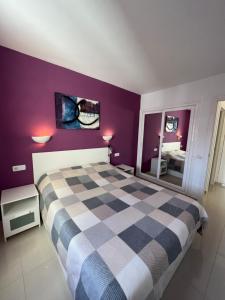 ロス・クリスティアーノスにあるApartment 409 El Carmenの紫の壁のベッドルーム1室(ベッド1台付)