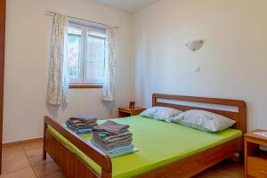 una camera da letto con letto con lenzuola verdi e finestra di Apartments by the sea Basina, Hvar - 11923 a Vrbanj