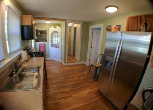 a kitchen with a stainless steel refrigerator and wooden floors at Harper Two Bedroom House in Historic Loveland in Loveland