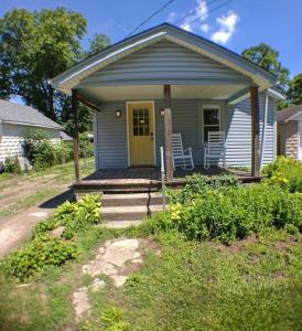 a small blue house with a porch and a yellow door at Harper Two Bedroom House in Historic Loveland in Loveland