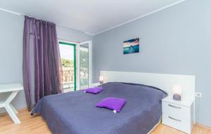a bedroom with a bed with purple pillows on it at Apartments by the sea Povlja, Brac - 12362 in Povlja
