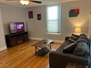 a living room with a couch and a table and a television at Main, Three Bedroom House in Historic Loveland in Loveland