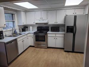 una cocina con armarios blancos y electrodomésticos de acero inoxidable en Ohio Ave 3 bed house Historic Downtown Loveland, en Loveland