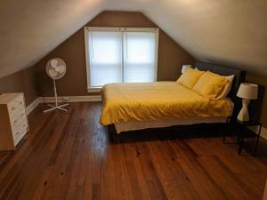 Un dormitorio con una cama amarilla y una ventana en Ohio Ave 3 bed house Historic Downtown Loveland, en Loveland