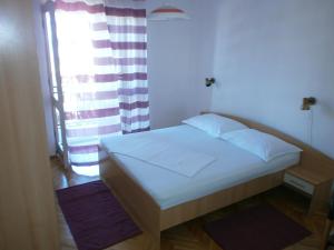 ein kleines Bett in einem Zimmer mit Fenster in der Unterkunft Apartments by the sea Podgora, Makarska - 12326 in Podgora