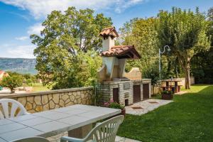 a backyard with a table and a fireplace at Apartments for families with children Blaskovici, Central Istria - Sredisnja Istra - 12398 in Kršan