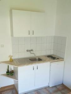 a kitchen with white cabinets and a sink at Apartments with a parking space Drvenik Donja vala, Makarska - 12297 in Drvenik +41 photos