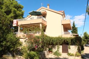 a house with a balcony with a green umbrella at Apartments with parking space Basina, Hvar - 12420 in Vrbanj