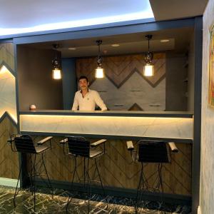 a man standing behind a counter in a bar at Grand Nergiz Otel in Antalya