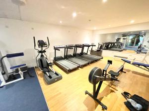 a gym with several treadmills and exercise bikes at Sea View Family Stay by Beach Gym & Parking in Bournemouth