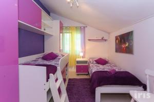 2 łóżka w pokoju z fioletowymi ścianami w obiekcie Apartments with a parking space Kastel Sucurac, Kastela - 12445 w mieście Kaštela