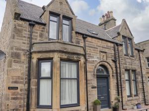 an old stone house with black windows and a turret at Firthview in Buckie