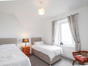 a bedroom with two beds and a window at Firthview in Buckie