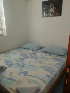 - un lit dans une chambre à côté d'un mur dans l'établissement Apartments by the sea Kabli, Peljesac - 12475, à Janjina