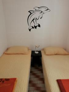 - 2 lits dans une chambre avec une étiquette murale dans l'établissement Apartments by the sea Kabli, Peljesac - 12475, à Janjina