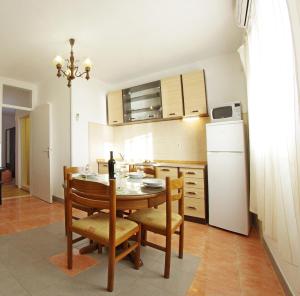 a kitchen with a table and chairs and a refrigerator at Apartments with parking space Sumartin, Brac - 12487 in Sumartin