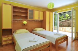 2 Betten in einem Zimmer mit gelben Wänden in der Unterkunft Apartments by the sea Slatine, Ciovo - 12491 in Slatine