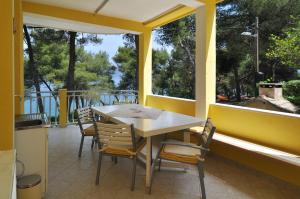 einen Tisch und Stühle auf einer Veranda mit Fenstern in der Unterkunft Apartments by the sea Slatine, Ciovo - 12491 in Slatine