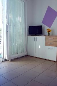 a living room with a tv and a tiled floor at Apartments by the sea Zaglav, Dugi otok - 12504 in Sali