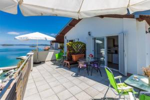 une terrasse avec une table, des chaises et un parasol dans l'établissement Apartments by the sea Zaglav, Dugi otok - 12504, à Sali