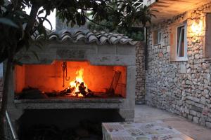 a brick fireplace with a fire in it at Holiday house with a parking space Borje, Peljesac - 12506 in Orebić
