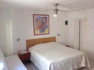 a bedroom with a bed and a painting on the wall at Apartments with a parking space Brsec, Opatija - 12524 in Mošćenička Draga